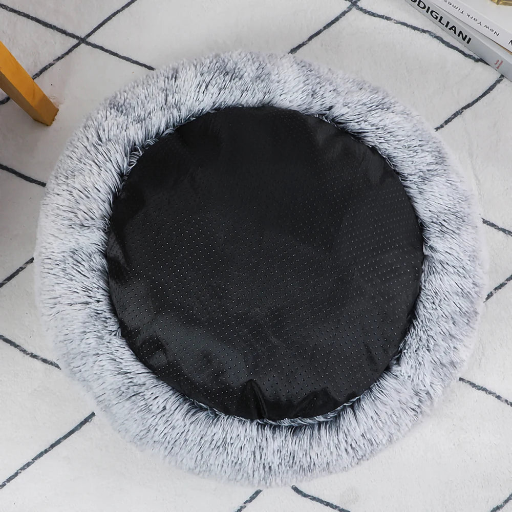 Round pet bed with fluffy gray exterior and black interior on a tiled floor.