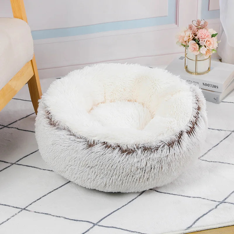 Fluffy white pet bed on a tiled floor with a light blue wall in the background.